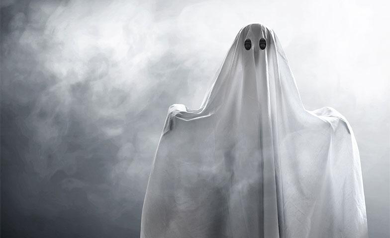 Image of person posing as ghost by wearing a sheet