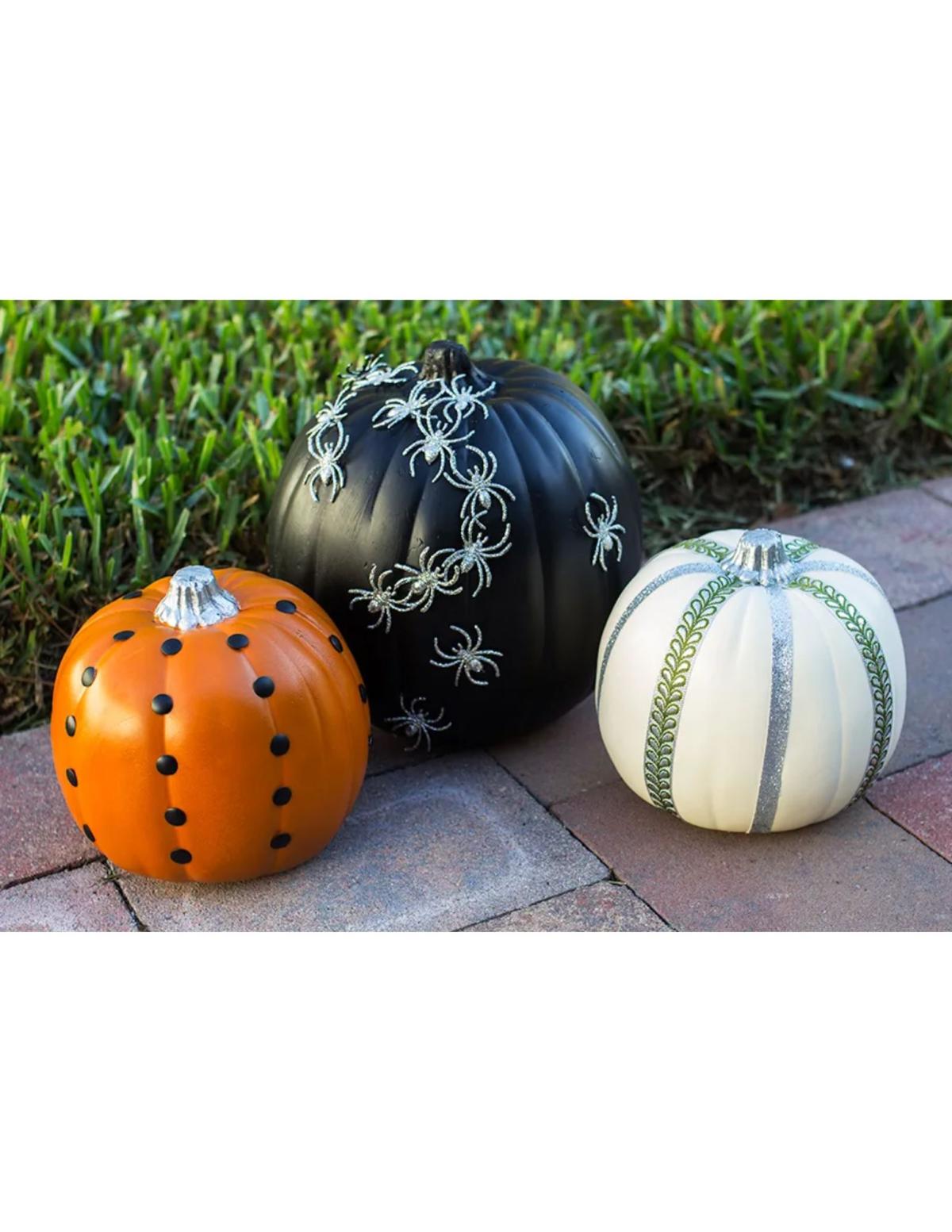 examples of decorated pumpkins with ribbon, spiders, and tacks