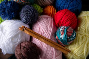 collection of different color yarns and needles for knitting and crochet