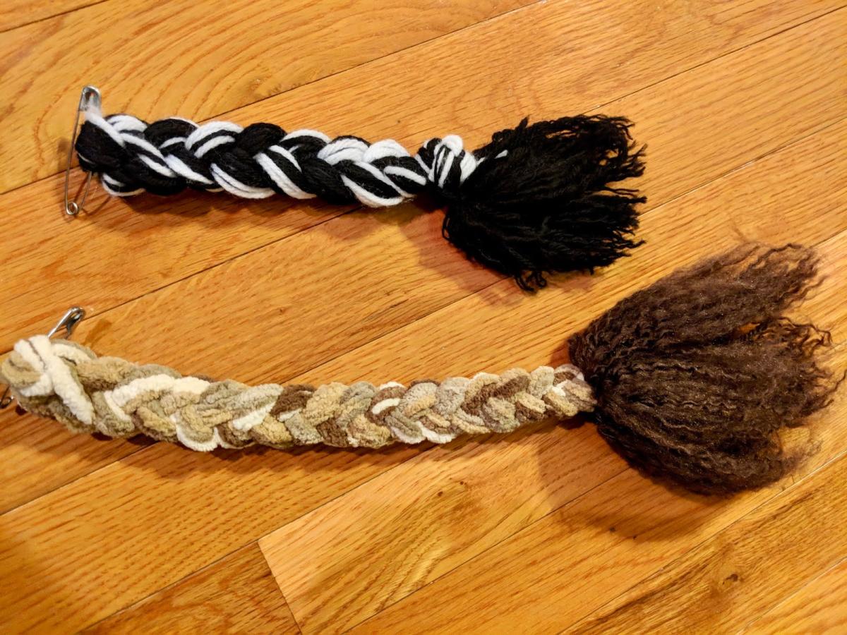Two fake animal tails made out of yarn